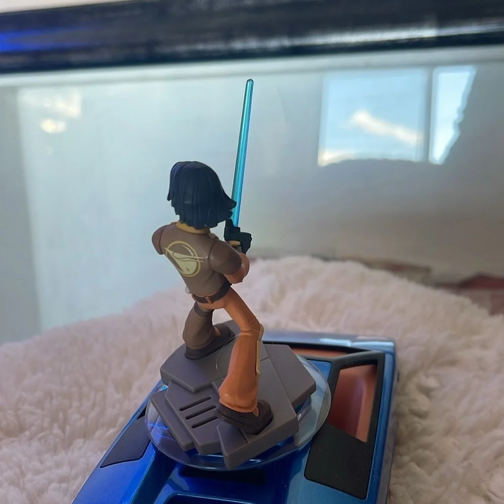 Action Figure with Blue Lightsaber on Vehicle